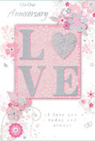 This romantic anniversary card design unfolds with the soft grace of a hand-tied bouquet, perfectly suited to mark another year together in Cheshunt. Across the centre, the word LOVE rises in embossed letters, their surfaces gently coated with fine glitter that shimmers between pale blush, creamy white, and cool silver when touched by the light. The slight relief of the letters is noticeable to the fingertips, offering a tactile pleasure reminiscent of textured petals or delicately wired foliage in a florist's creation. Flowing around this central word, a chorus of stylised flowers, buds, and leaves sweeps in slender, curving lines. These elements are rendered in subtle shades of pink, ivory, and gentle grey, with tiny silver highlights that catch the eye like dewdrops on early-morning blooms in gardens near Cheshunt Brookfield. The blossoms are dreamy rather than literal, suggesting romantic spring flowers without tying them to specific varieties, allowing the design to feel timeless. The soft pink background provides a consistent, calming canvas, adding warmth and a sense of intimacy. Threaded among the flowers and raised letters is an elegantly scripted anniversary message, written in a flowing, graceful hand that expresses deep affection and enduring partnership. The entire composition feels balanced, airy, and quietly joyful, creating the impression of a keepsake cherished long after the day has passed. It is easy to imagine this card nestled beside a vase of fresh anniversary flowers delivered in Cheshunt, the paper and petals together telling a story of shared memories and continuing love.